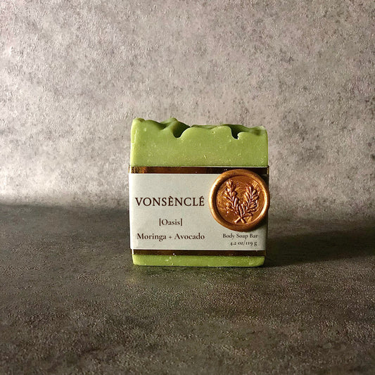 A green-colored soap bar, labeled with Vonsènclé's grey wrap-around gold foil label and gold wax seal.