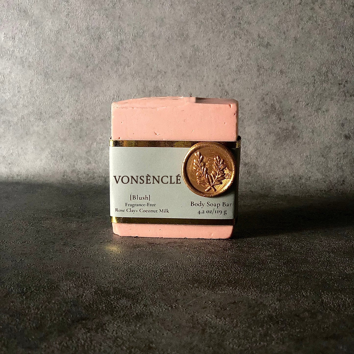 Pink soap bar with a grey and gold foil label with a wax stamped seal