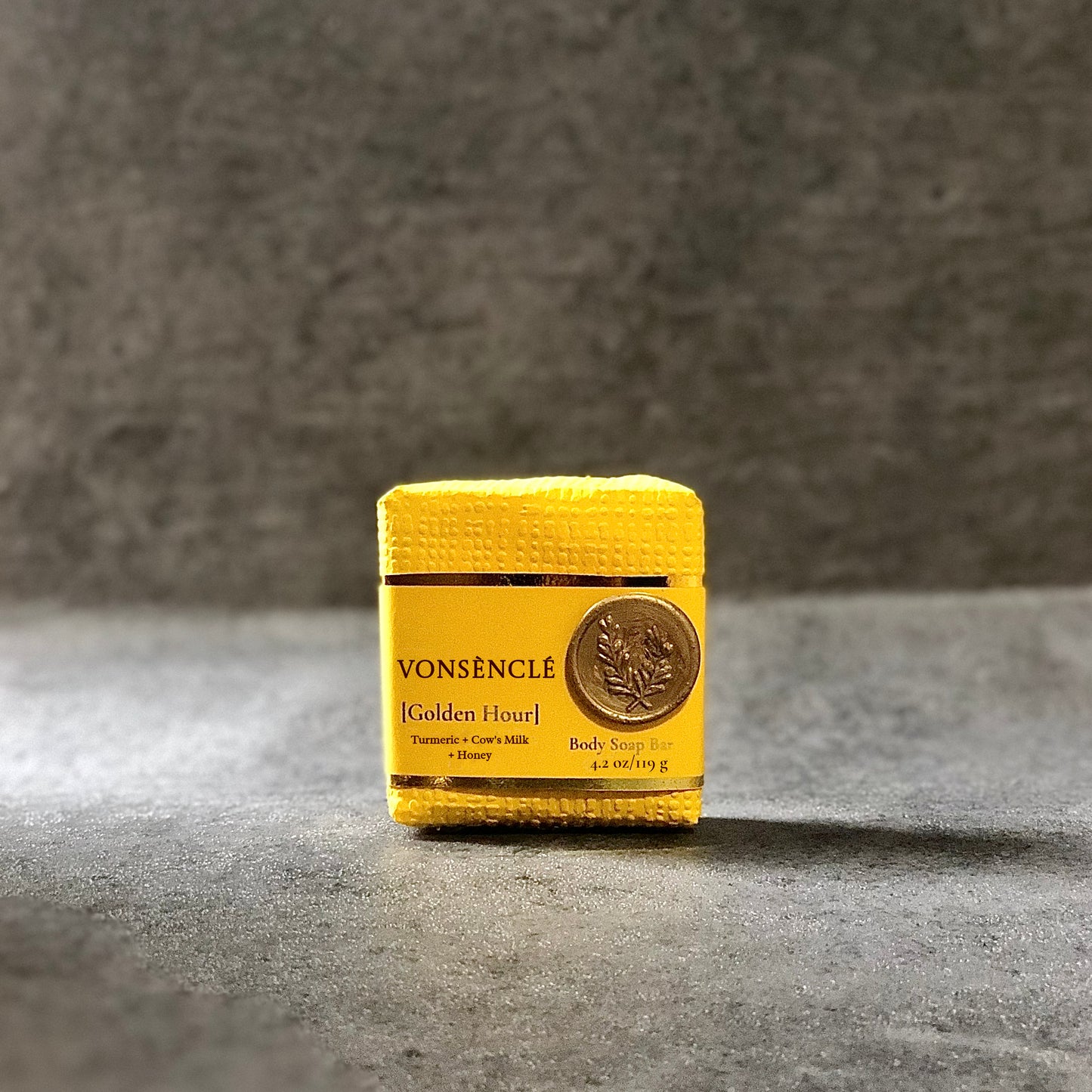 A dark-yellow packaged soap bar with 'Vonsènclé' branding on a gray surface.
