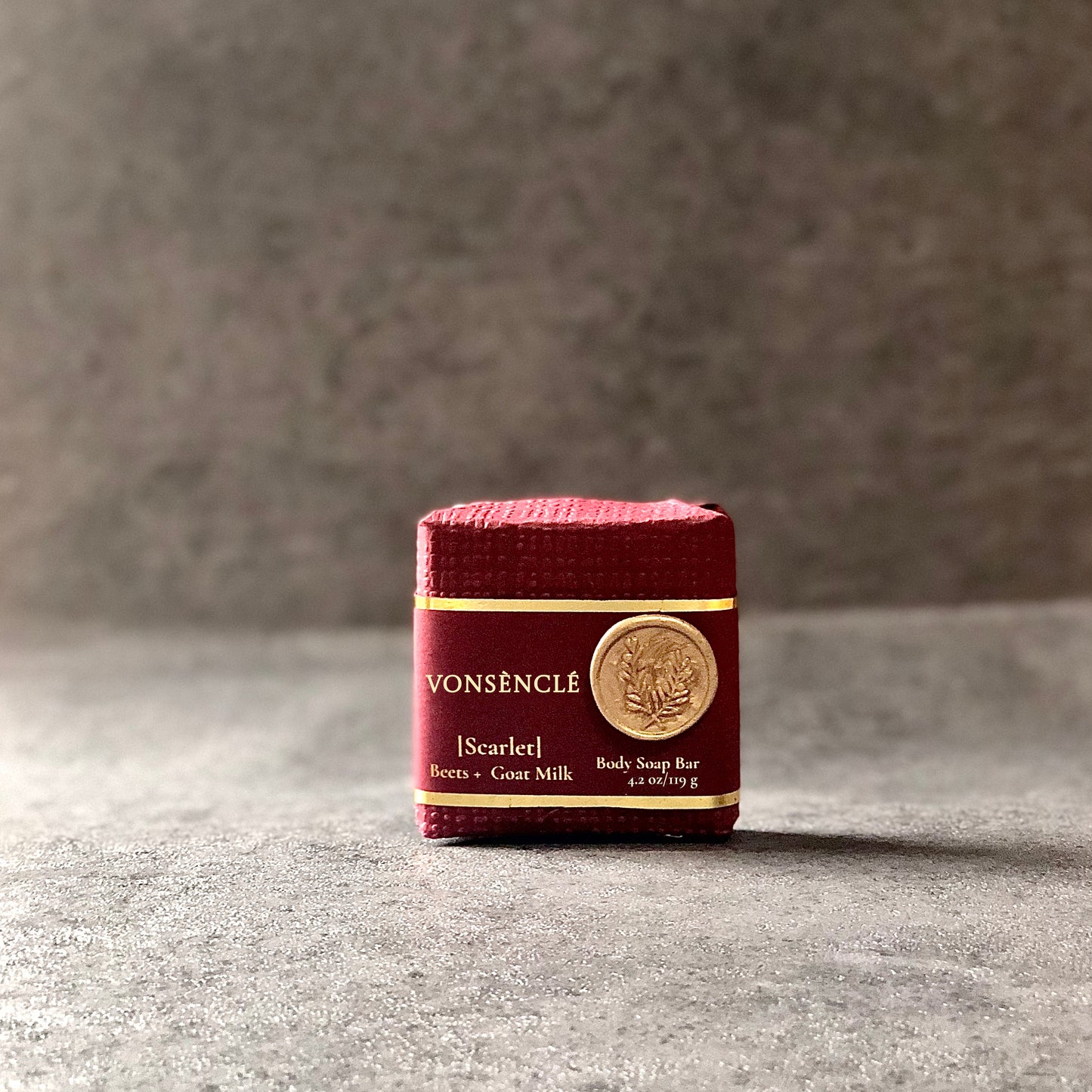Vonsènclé's soap wrapped in burgundy-red-colored packaging.