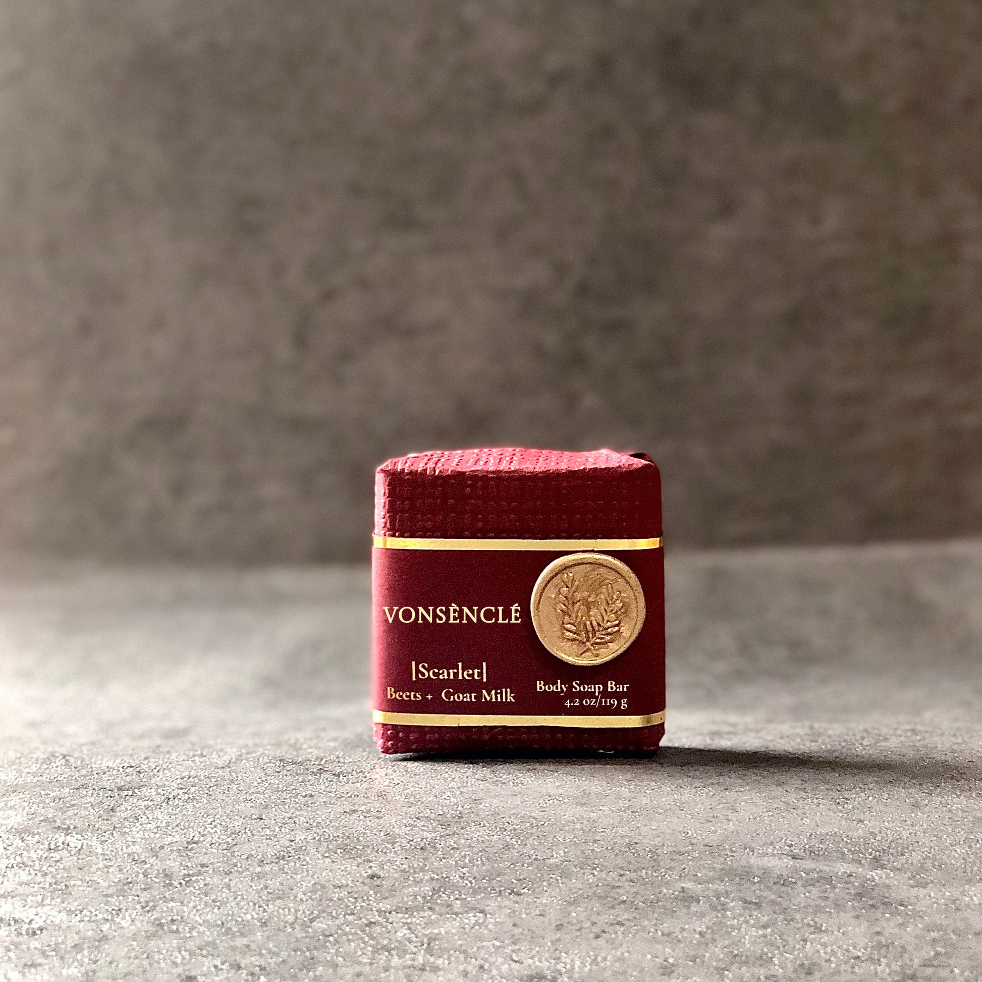 Vonsènclé's soap wrapped in burgundy-red-colored packaging.
